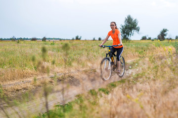 Woman is riding a bicycle, an active lifestyle.