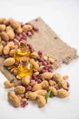 Natural peanuts with oil in a glass jar on a white background