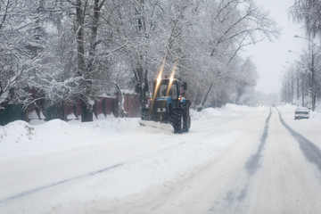 Tractor cleaning snow on the road