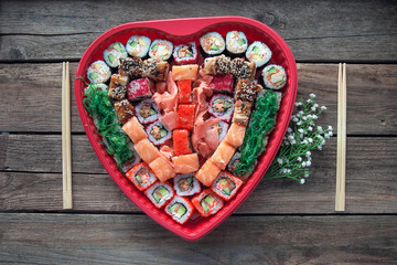 Sushi on a old wooden table background with a heart shaped decor