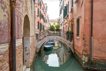 Fototapeta na wymiar Typical small canal in Venice with nice bridges and boats