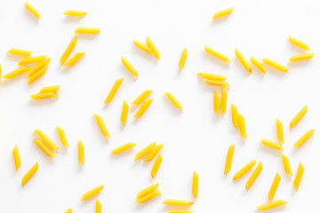 Pasta background. Raw penne on white background top view