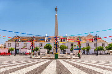 Vila Real de Santo Antonio, Algarve, Portugal. The attractive paving and monument of the town's main plaza with festival bunting