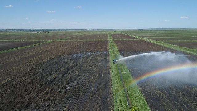 Aerial view of Crop Irrigation using the center pivot sprinkler system. An irrigation pivot watering agricultural land. Irrigation system watering farm land.