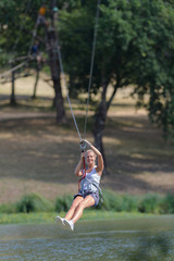 confident joyful woman climbing in the rope park