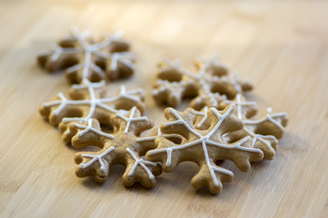 Traditional Czech tasty white painted brown gingerbreads, Christmas snowflakes on wooden table
