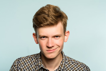 smug smile. man with a self satisfied smirk. portrait of a young guy on light background. emotion...