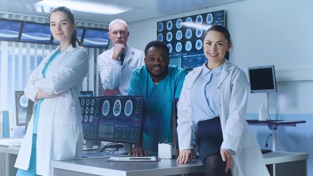 Diverse Team of Medical Scientist Posing with Crossed Arms in the High-Tech Laboratory. Brain Sceince / Neurology Center Research Lab with Multiple Dispalys Showing CT / MRI Scan Images. 