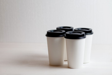 Coffee in blank white paper cups takeaway with caps. on white background.
