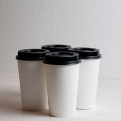 Coffee in blank white paper cups takeaway with caps. on white background.