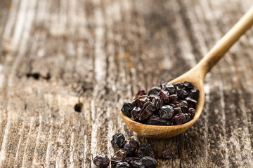 Spoon of barberry on a wooden background