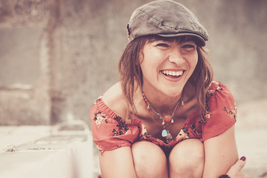nice beautiful young woman smiling and laughing in vintage colors and summer style trendy look. fashion and nice causacian girl sitting sexy outdoor activity. defocused background