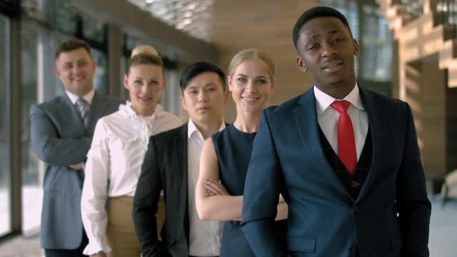 Portrait of handsome black business man with four employees in the business hall