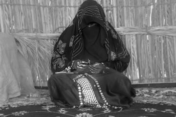 Emirati woman is in the process of weaving traditional basket - obrazy, fototapety, plakaty