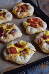 Mini pies made of puff pastry, custard and caramelized rhubarb. Homemade baking. Delicious freshly baked cookies. Rustic photo