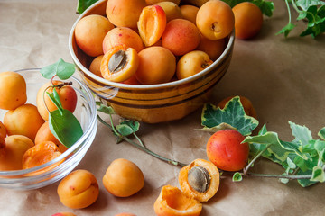 Fototapeta na wymiar Ripe apricots in a bowl with green leaves