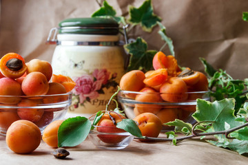 Ripe apricots in a bowl with green leaves