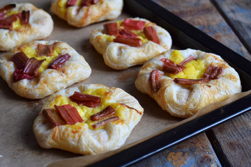 Mini pies made of puff pastry, custard and caramelized rhubarb. Homemade baking. Delicious freshly baked cookies. Rustic photo