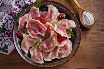 Dumplings, filled with strawberries, berries. Pierogi, varenyky, vareniki, pyrohy - dumplings with filling, popular dish in many countries. overhead, horizontal