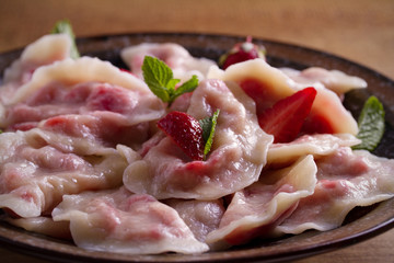 Dumplings, filled with strawberries, berries. Pierogi, varenyky, vareniki, pyrohy - dumplings with filling, popular dish in many countries. horizontal