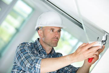 electrician fixing light on ceiling