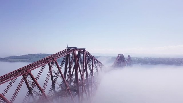 Aerial shot of the Edinburgh Forth rail Bridge, descending through the fog