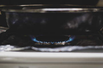 Una sarten calentÃ¡ndose en una estufa con una flama azul 