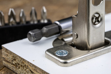 Mounting hinges for chipboard furniture. Joinery accessories used when assembling kitchen furniture.