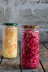 Sauerkraut in glass jar, marinated cabbage, carrot and beetroot. Probiotic and fermented food. Pickles. Canned vegetarian food concept.