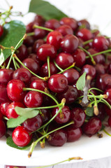 Cherries in a plate. Fresh cherries and leaves.