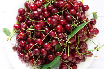 A plate with red cherries is a top view.