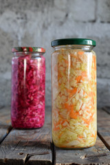 Sauerkraut in glass jar, marinated cabbage, carrot and beetroot. Probiotic and fermented food. Pickles. Canned vegetarian food concept.
