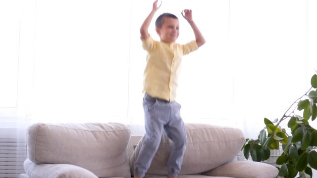 Cute Boy Having Fun While Jumping On Sofa