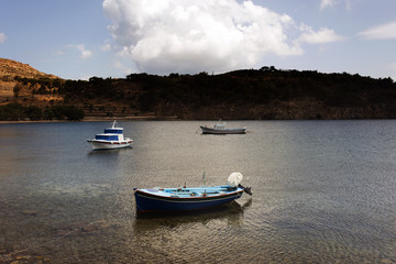 Three fishing boats in the sea in the island of Patmos, Greece in summer time