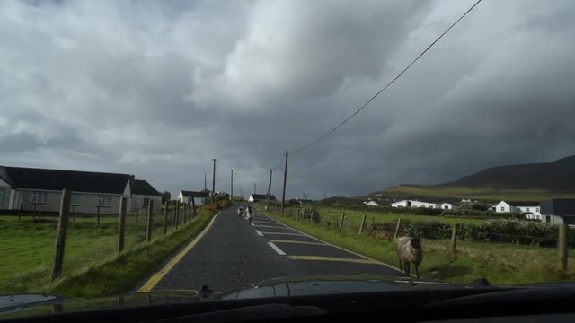 car moving through irish village on Achill Island, Ireland.