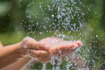Water pouring in woman's hands. World Water Day concept.