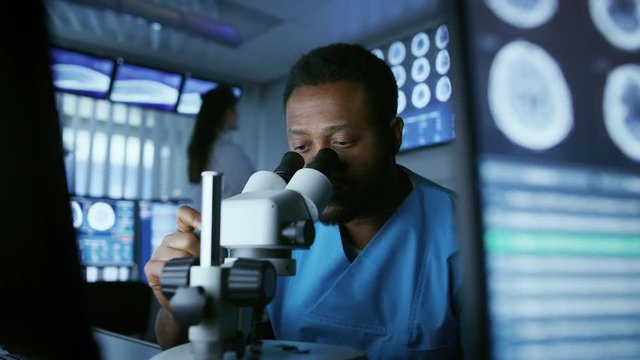 Medical Research Scientist Looking under the Microscope in the Laboratory. Neurologist Solving Puzzles of the Mind and Brain.