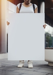 Close Up Of Young Woman Holding Blank Canvas Placard Outdoors. Activist Protesting Against Political and Social Issues. Copy Space. Empty Space. Single Person Protest In The City