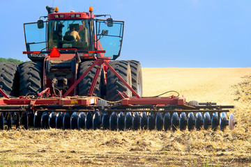 red tractor for harvesting in the midst of the summer season, produces disk field