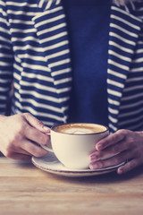 Girl having a break with cup of coffee, close up, soft focus, vintage filter.