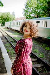 A lovely girl stands near the train