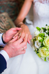 Obraz na płótnie Canvas Groom putting wedding ring on bride's finger, closeup