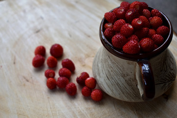  ripe red forest strawberries in a pot