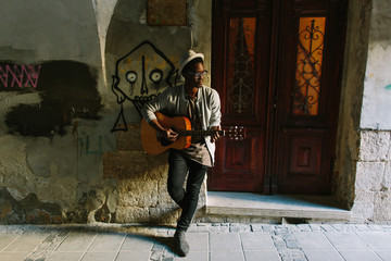 African musician playing guitar in the city