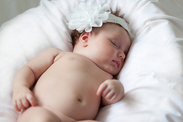 Newborn baby girl sleeping on a summer day at home