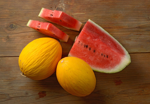 yellow melon and red watermelon on wooden table - sicilian fruit