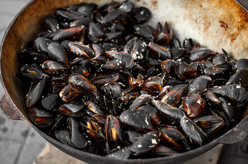 The process of preparing mussels in a large saucepan. Street food with seafood.
