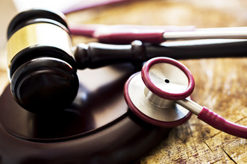 Medical law concept. Gavel and stethoscope on wooden table