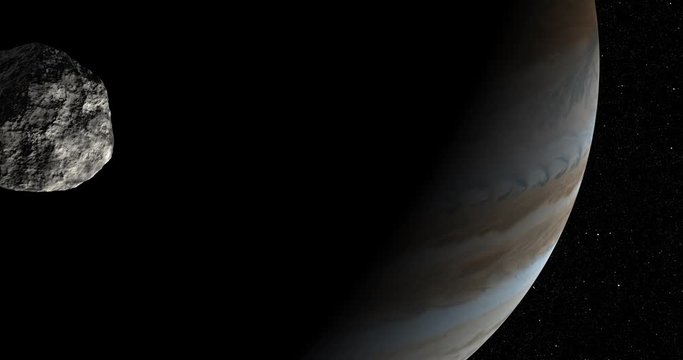 An asteroid tumbles slowly in space as it passes Jupiter. Reversible, can be rotated 180 degrees. Elements of this image furnished by NASA.