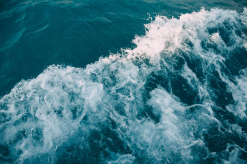 Fototapeta na wymiar Dark turquoise waves of the Aegean Sea diverging from the yacht. Turkey, Bodrum.